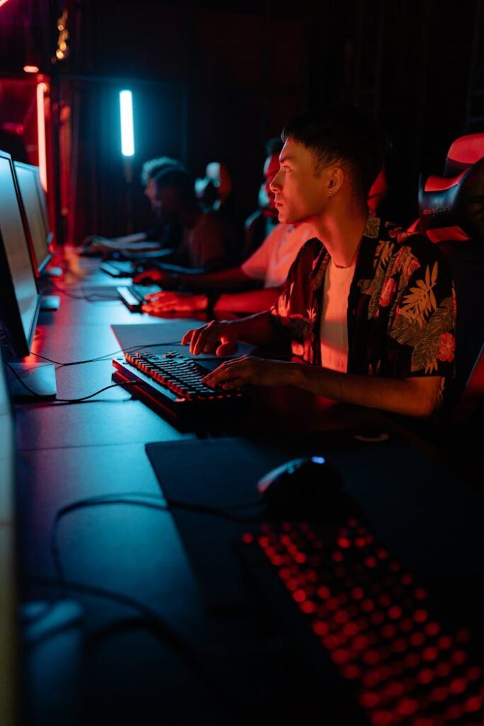 pexels photo 9072387 Gamers in a stylish esports café illuminated by vibrant blue and red neon lights.
